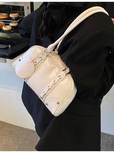 Vintage glossy cream leather tote bag with rivet details shown on a model's shoulder