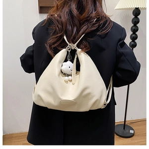 Detail of off-white PU leather multi-way backpack with a cute plush cloud charm