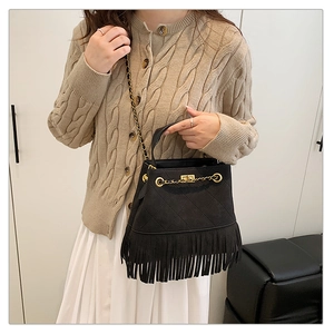 Détail du sac seau à franges noir avec coutures matelassées et chaîne dorée sur mannequin