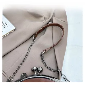 Detail der braunen Retro-Muscheltasche mit Metallverschluss und Ketten-Schulterriemen