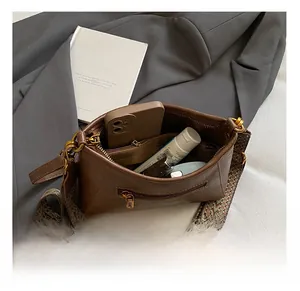 Detail showing the internal storage of a brown leather bag with a woven shoulder strap