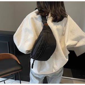 Détail de la sacoche bandoulière noire matelassée avec sangle sur mannequin
