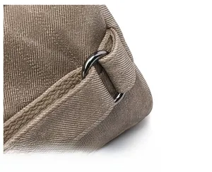 Detail of durable metal D-ring and reinforced stitching on khaki canvas shoulder bag strap