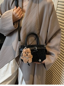 Leopard print crossbody bag with plush bear charm worn by a model in a beige trench coat