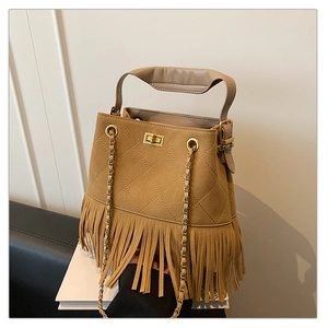 Détail du sac seau en daim kaki avec matelassage, franges et fermoir rotatif doré élégant