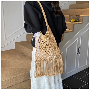 Detail of khaki woven tote bag with fringe, hollow mesh texture and pearl bow charm