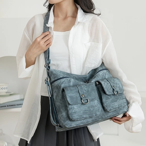 Detail view of vintage blue washed leather handbag with functional pockets and metal hardware
