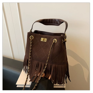 Détail d'un sac seau en daim marron foncé avec de longues franges et matelassage