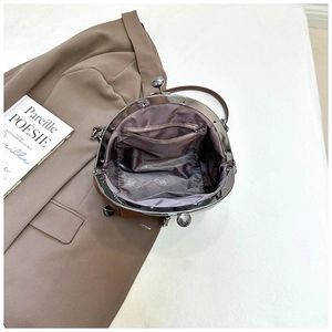 Detailansicht der braunen Vintage-Tasche mit lila Innenfutter und Reißverschlusstasche