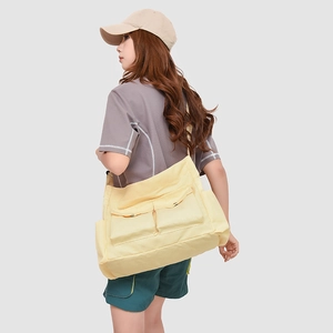 Détail du sac fourre-tout jaune en tissu Oxford avec poches multiples et large bandoulière