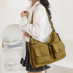 Detail of mustard yellow large tote bag with two front pockets and D-ring metal buckles