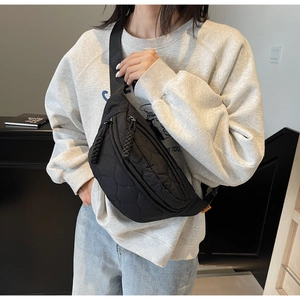 Détail de la sacoche de poitrine en toile matelassée noire avec motif à losanges et zip