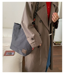 Dettaglio della borsa tote a quadretti blu grigio con logo in pelle e etichetta rossa