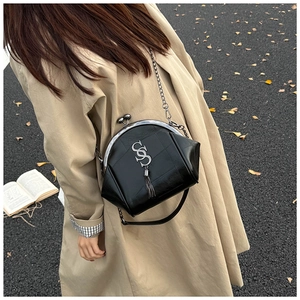 Detail der schwarzen Vintage-Ledertasche mit Goldquaste und Klippverschluss
