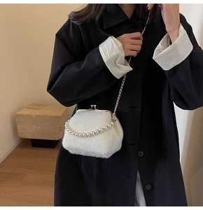 Détail d'un sac à bandoulière en peluche blanche avec poignée de perles et chaîne dorée