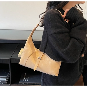 Detail of beige hobo bag made of frosted leather with adjustable shoulder strap