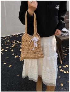 Close-up of handmade woven mesh tote with khaki rope texture and pearl lace bow detail