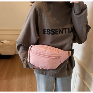 Vue latérale détaillée du sac banane matelassé rose avec surpiqûres et étiquette orange