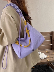 Purple nylon crossbody bag with ruched shoulder strap and yellow rope decorative accents