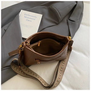 Detail view of dark brown retro crossbody bag with wide woven strap and inner zipper pocket