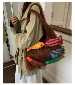 Detail of large brown plush tote bag featuring colorful 3D fish shaped plush decorations