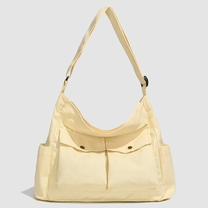 Détail d'un grand sac fourre-tout en toile crème avec poches à boutons-pression et bandoulière
