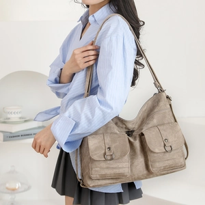 Detail of vintage textured tote bag with utility flap pockets and metallic button accents