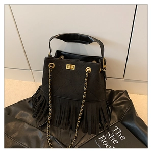 Gros plan du sac seau noir matelassé à franges avec fermoir rotatif en métal doré chic