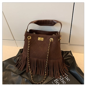 Détail d'un sac seau vintage en daim marron avec franges et surpiqûres losanges