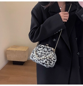 Détail du sac en fausse fourrure léopard avec poignée en perles et bandoulière dorée sur modèle