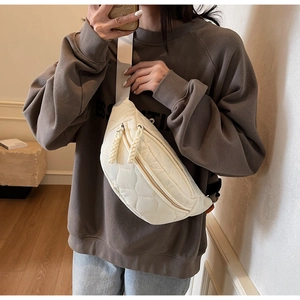 Détail du sac bandoulière beige matelassé avec double fermeture éclair et cordon