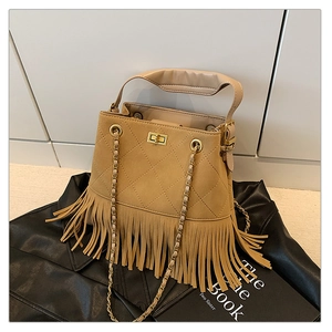 Détail du sac seau à franges kaki avec motifs matelassés et chaîne dorée sur cuir noir
