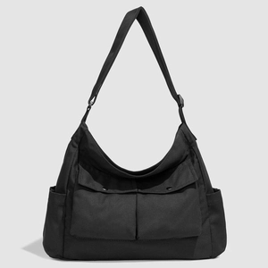 Détail des poches en tissu Oxford et de la bandoulière réglable sur un sac noir