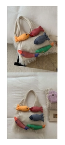 Detail of a beige knit tote bag with colorful fish plushies and fringe decorations