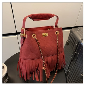 Détail du sac seau bordeaux à franges avec surpiqûres en losange et fermoir doré