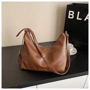 Detail des verstellbaren Riemens und der Gold-Schnalle an der braunen Leder-Hobo-Tasche