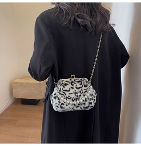 Sac coque en peluche léopard avec fermoir doré et chaîne perlée sur manteau noir