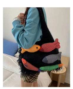 Close-up of large black plush tote bag featuring colorful fish plush charms on the side