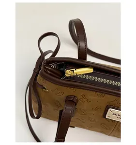 Détail du zip doré fluide sur un sac à main marron avec motifs embossés élégants