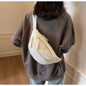 Vue de dos du mannequin portant un sac banane en toile matelassée blanche à sangle