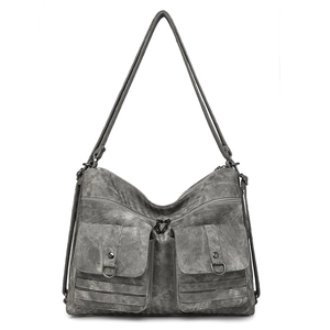 Detail of grey matte texture backpack featuring double flap pockets and metal buckle hardware