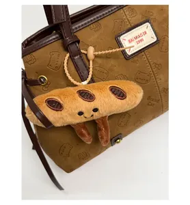 Détail d'un joli pendentif baguette en peluche avec broderie sur un sac en cuir brun