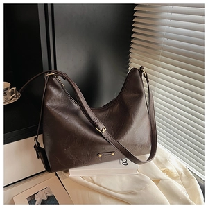 Nahaufnahme der braunen Hobo-Tasche aus Leder mit verstellbarem Gurt und Goldbeschlag