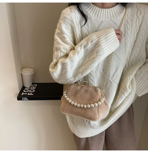 Sac bandoulière en peluche avec poignée perle et chaîne dorée porté par un mannequin