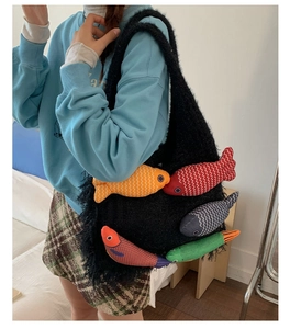 Detail of black fuzzy tote bag with colorful fish patches on soft knit material