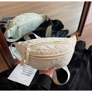 Detail der cremefarbenen Stepp-Gürteltasche mit Rautenmuster und verstellbarem Gurt