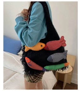 Detail of black faux fur shoulder bag featuring colorful 3D plush fish decorations