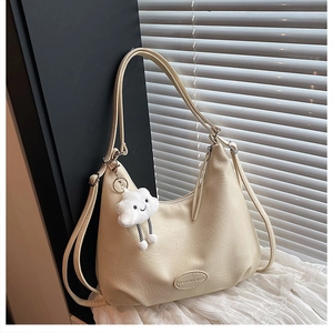 Detail of cream white PU leather tote with litchi texture and cloud plush charm pendant