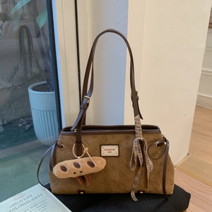 Vue détaillée du sac cabas rétro marron avec motifs de chat et breloque en peluche