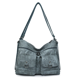 Close-up of grey-blue retro backpack showing dual front pockets and metal D-rings